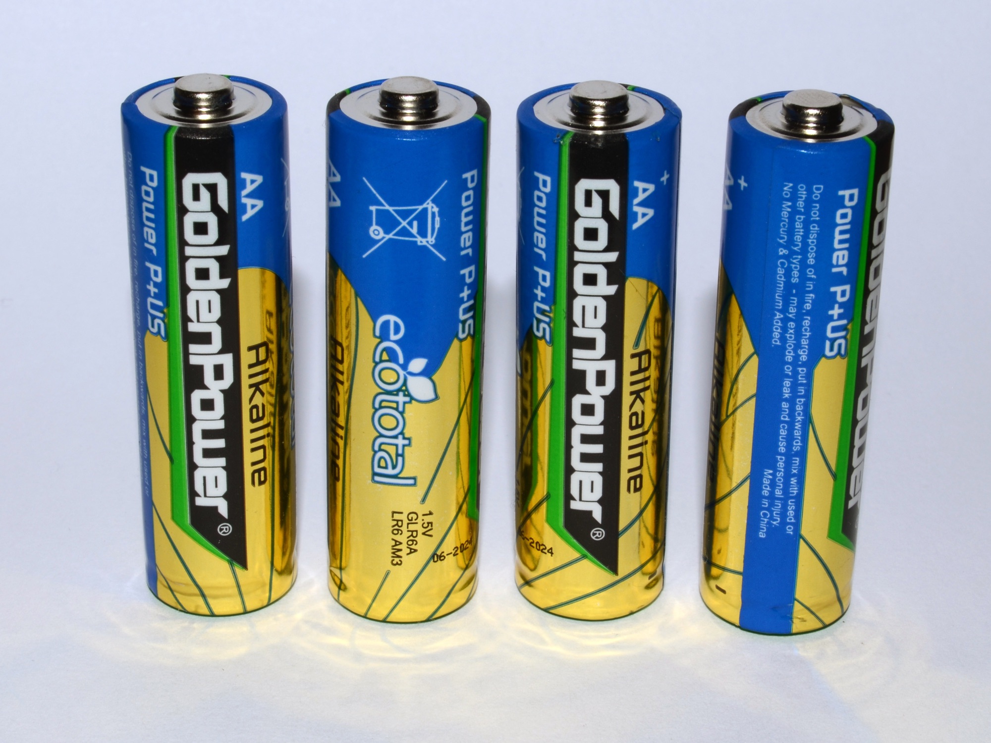 Four Golden Power AA alkaline cells standing against a pale background.