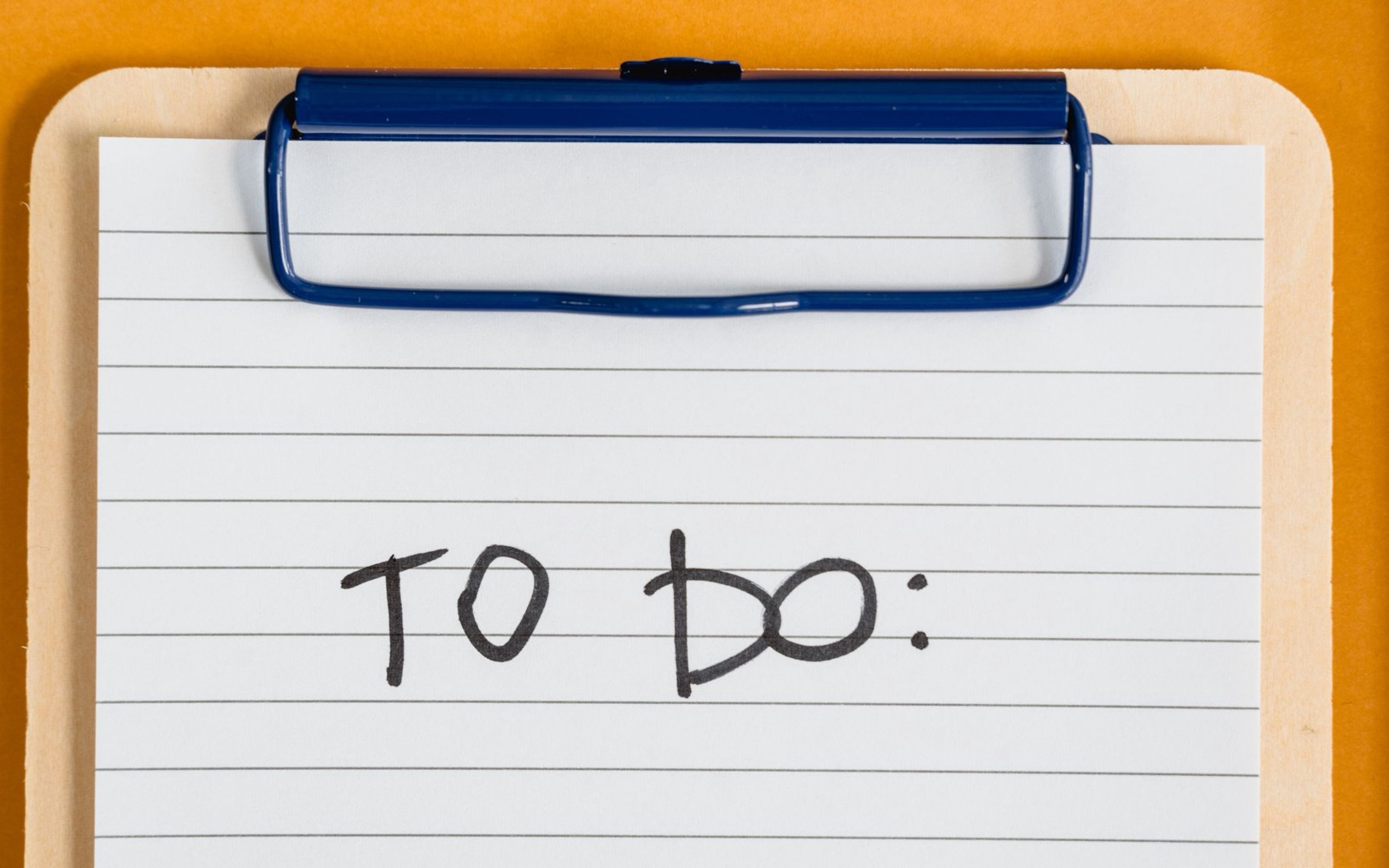 A clipboard and lined checklist on an orange background, used as an editorial illustration for ISO 9001 factory-evidence checks.