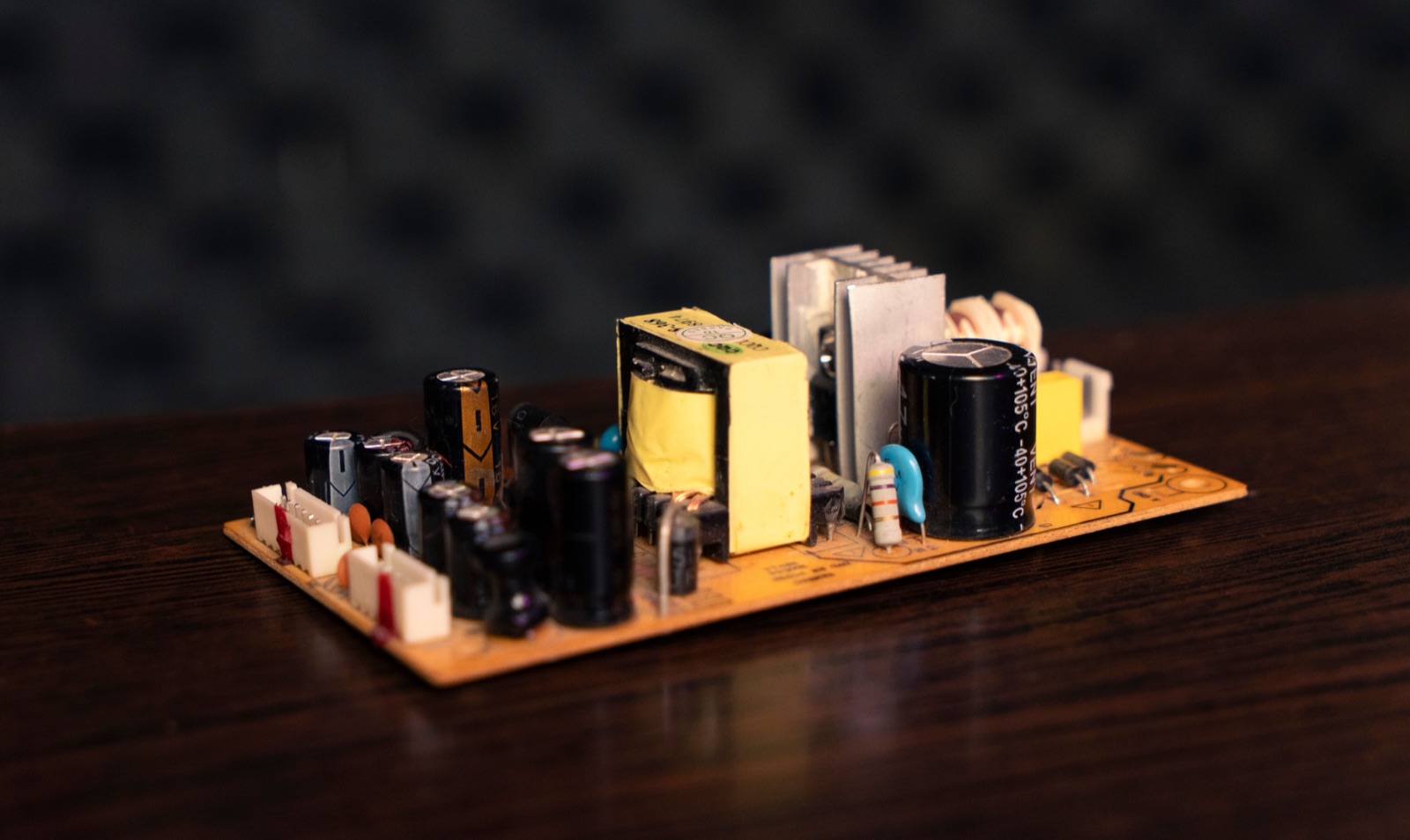 An electronic power-supply board with capacitors, transformers and heat sinks.