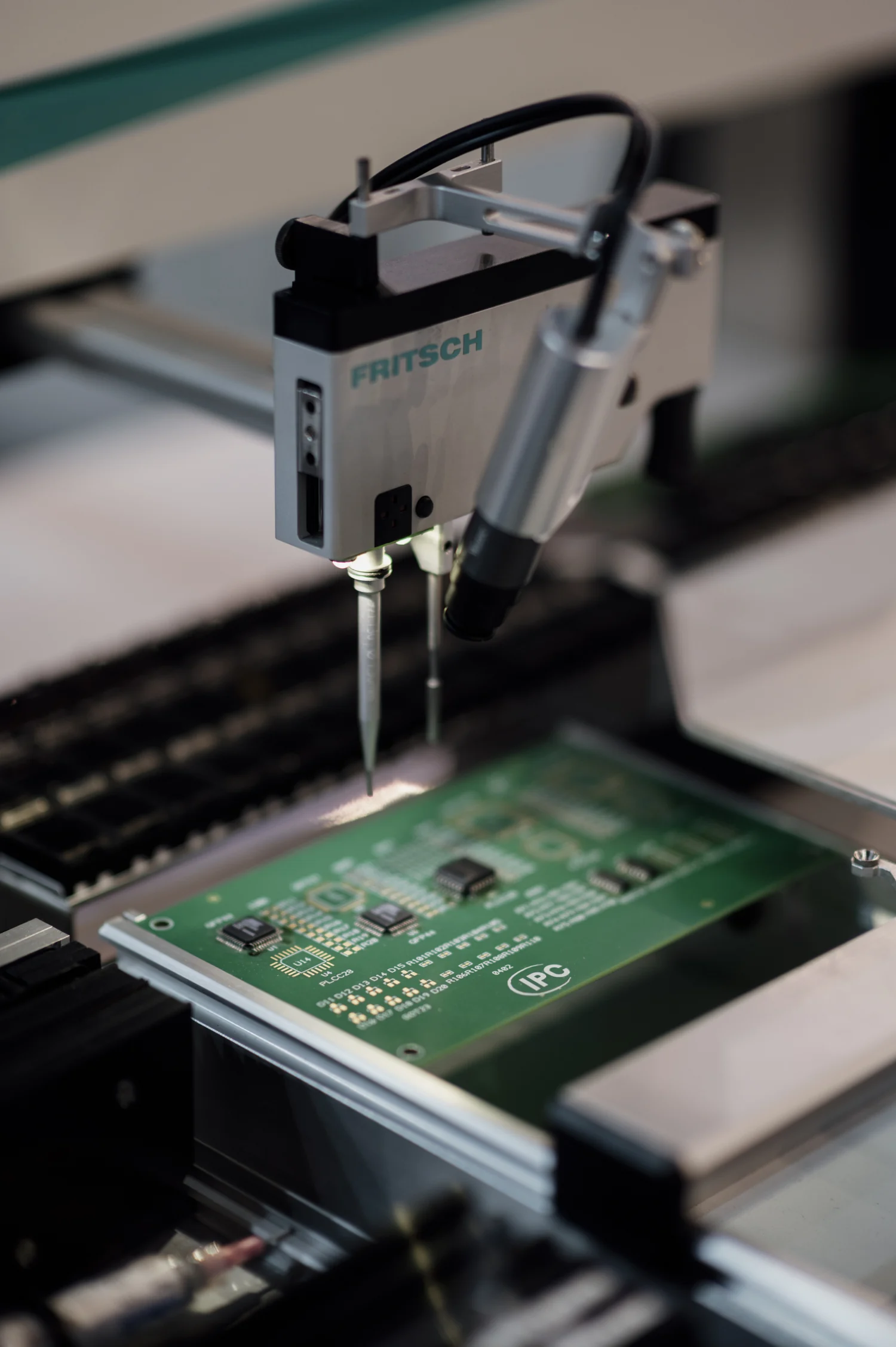A component-placement machine working over an electronic circuit board.